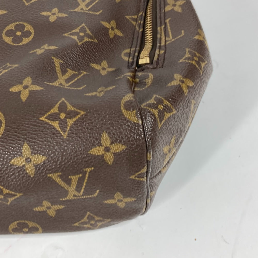 Brown handbag with gold monogram pattern on a white background