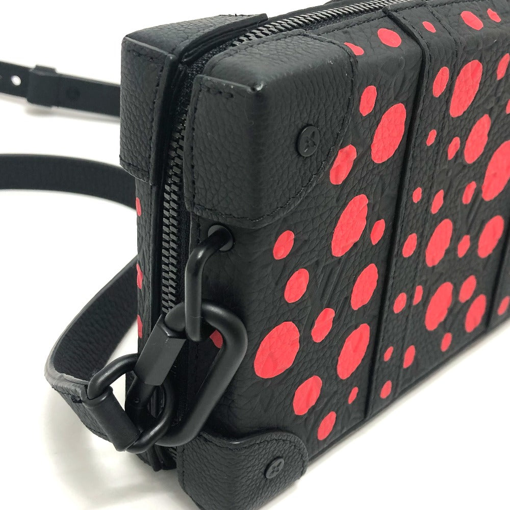 Black leather bag with red polka dot pattern and black strap on a white background