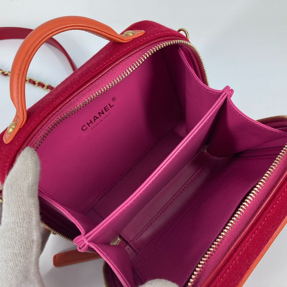 Pink handbag with orange handles and visible Chanel logo on a light gray background