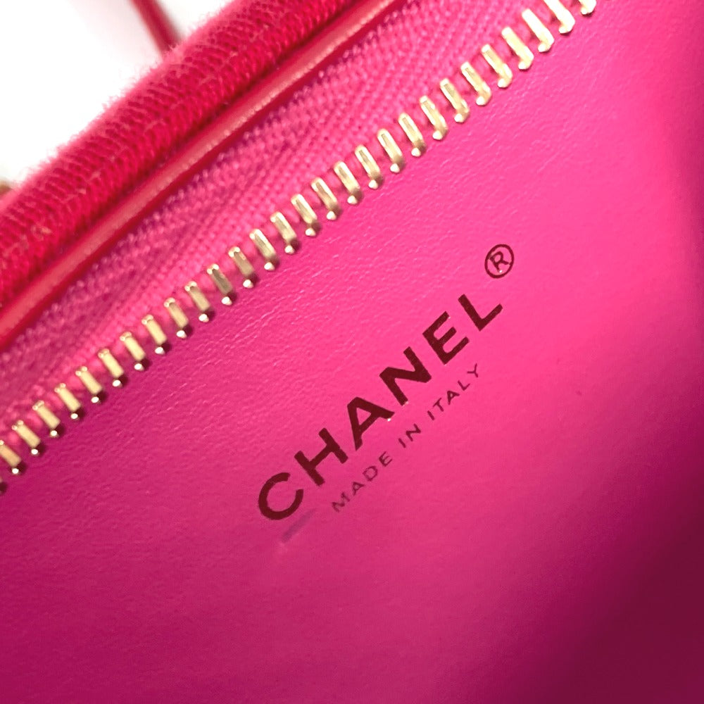 Close-up of a pink Chanel handbag with gold zipper.