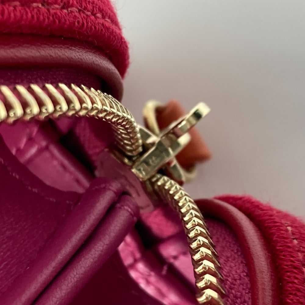Close-up of a pink handbag with a gold chain detail