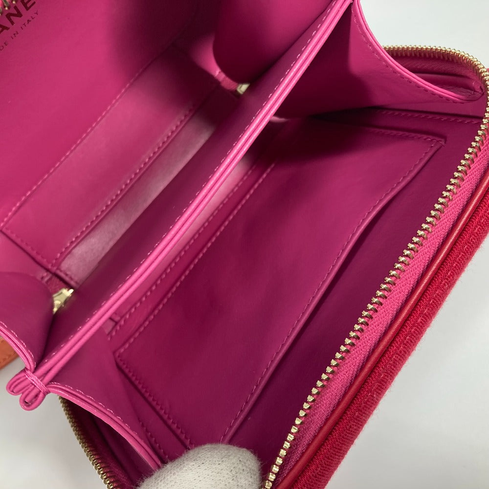 Close-up of a pink wallet with gold zipper on a white background