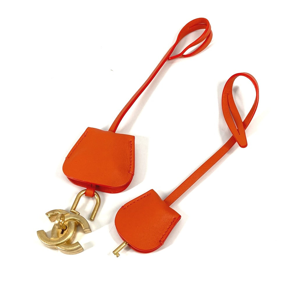 Orange leather strap with gold hardware on a white background