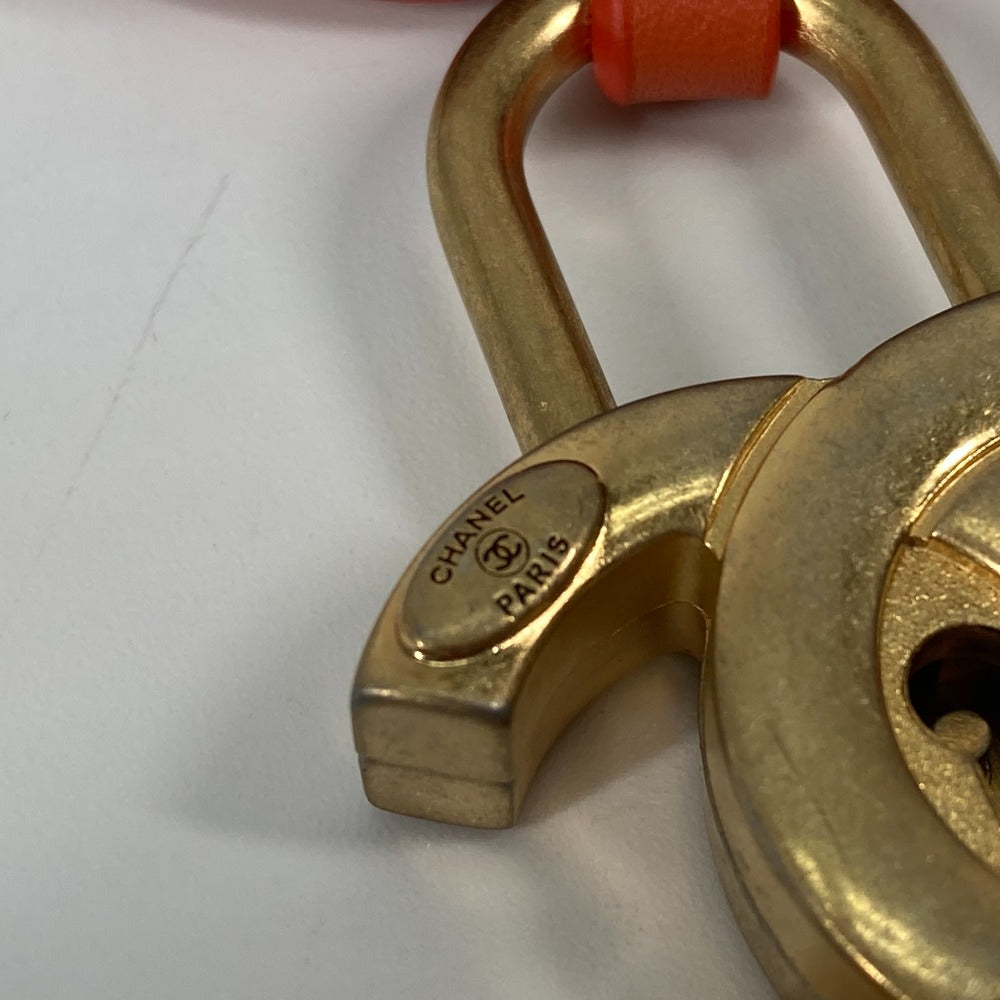 Gold padlock with Chanel logo on a white background