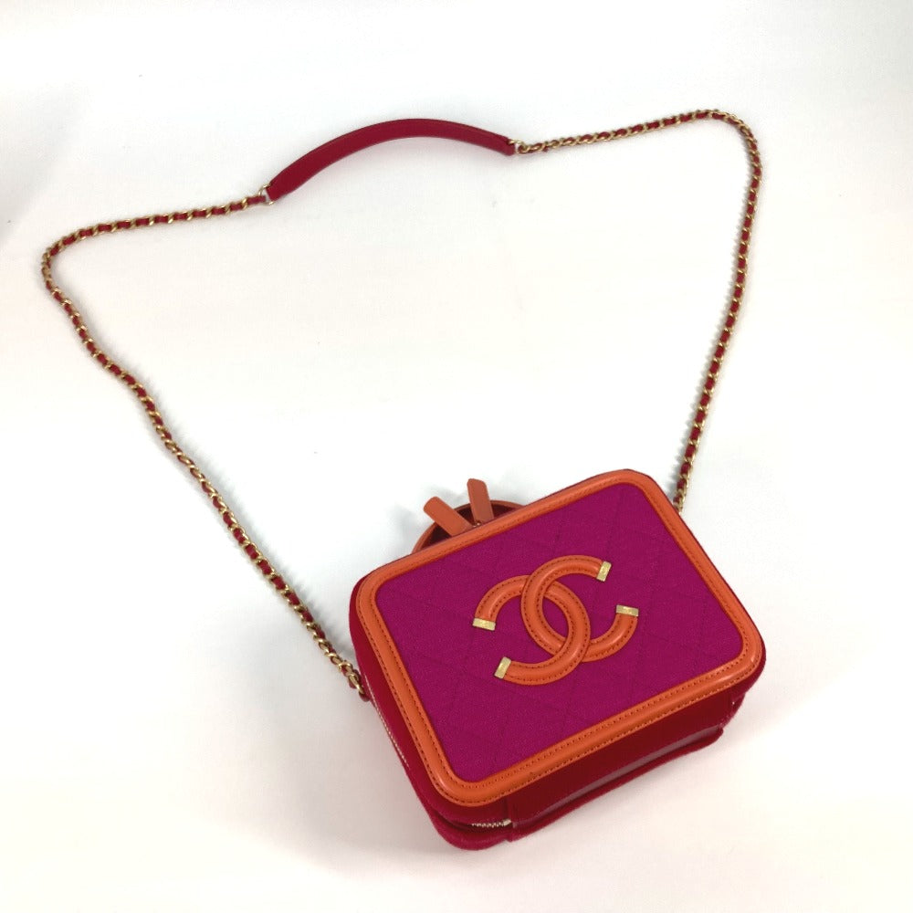 Chanel handbag with pink body and gold chain strap on a white background