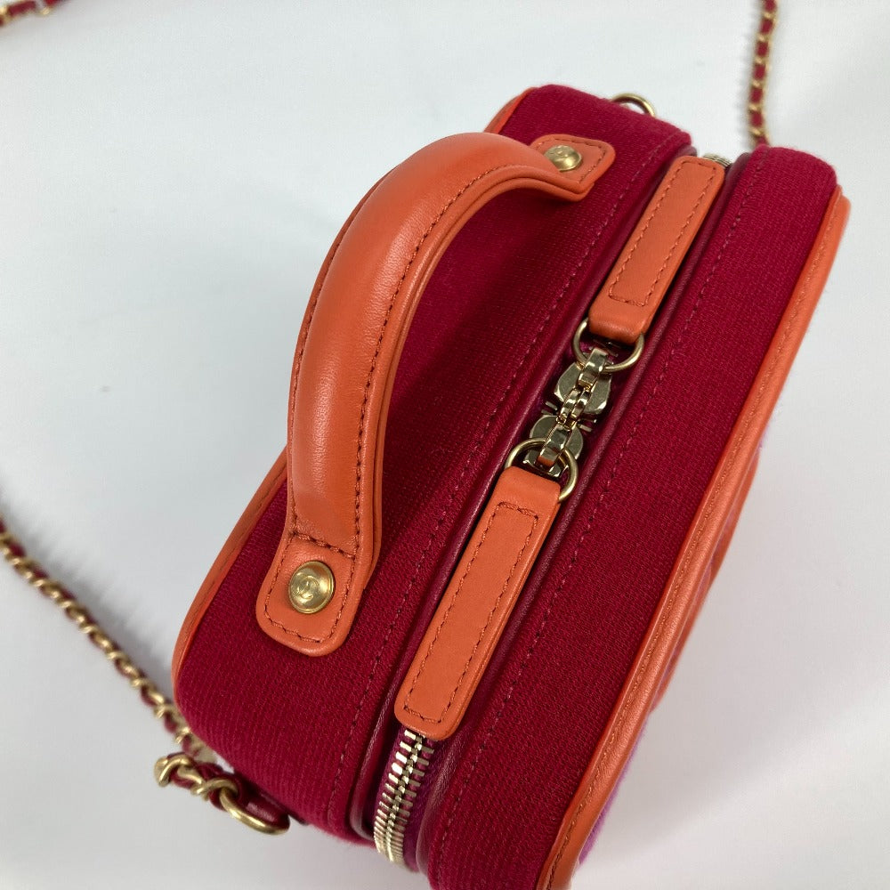 Red handbag with orange accents and gold zippers on a white background