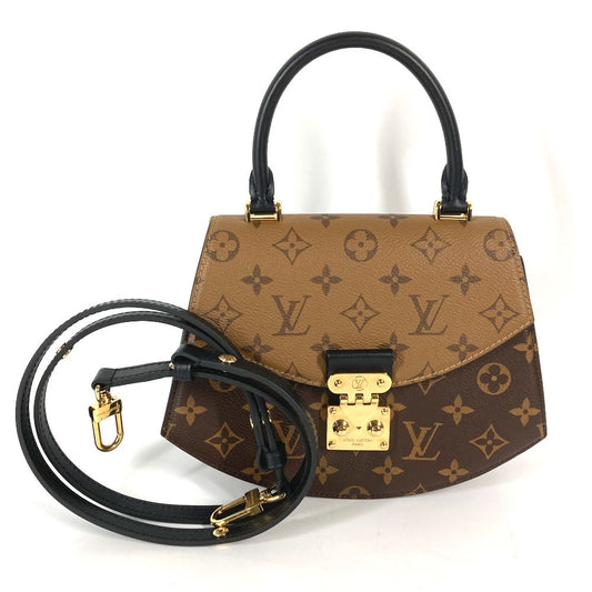 Designer handbag with monogram pattern and gold hardware on a white background