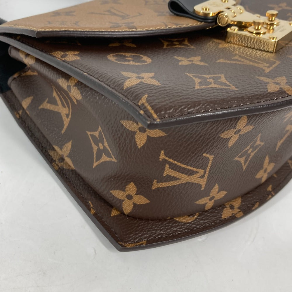 Louis Vuitton handbag with monogram pattern on a light gray background