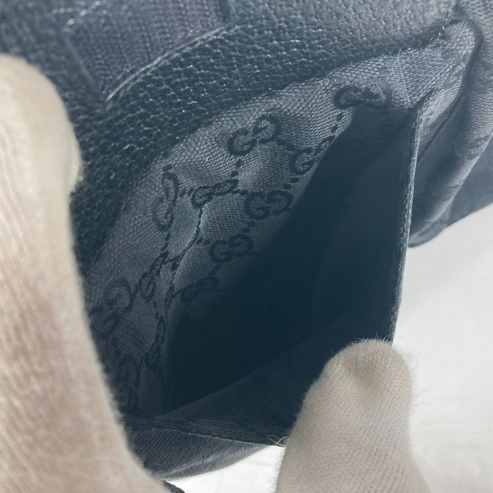 Close-up of a textured fabric with a brand logo, held by a gloved hand.