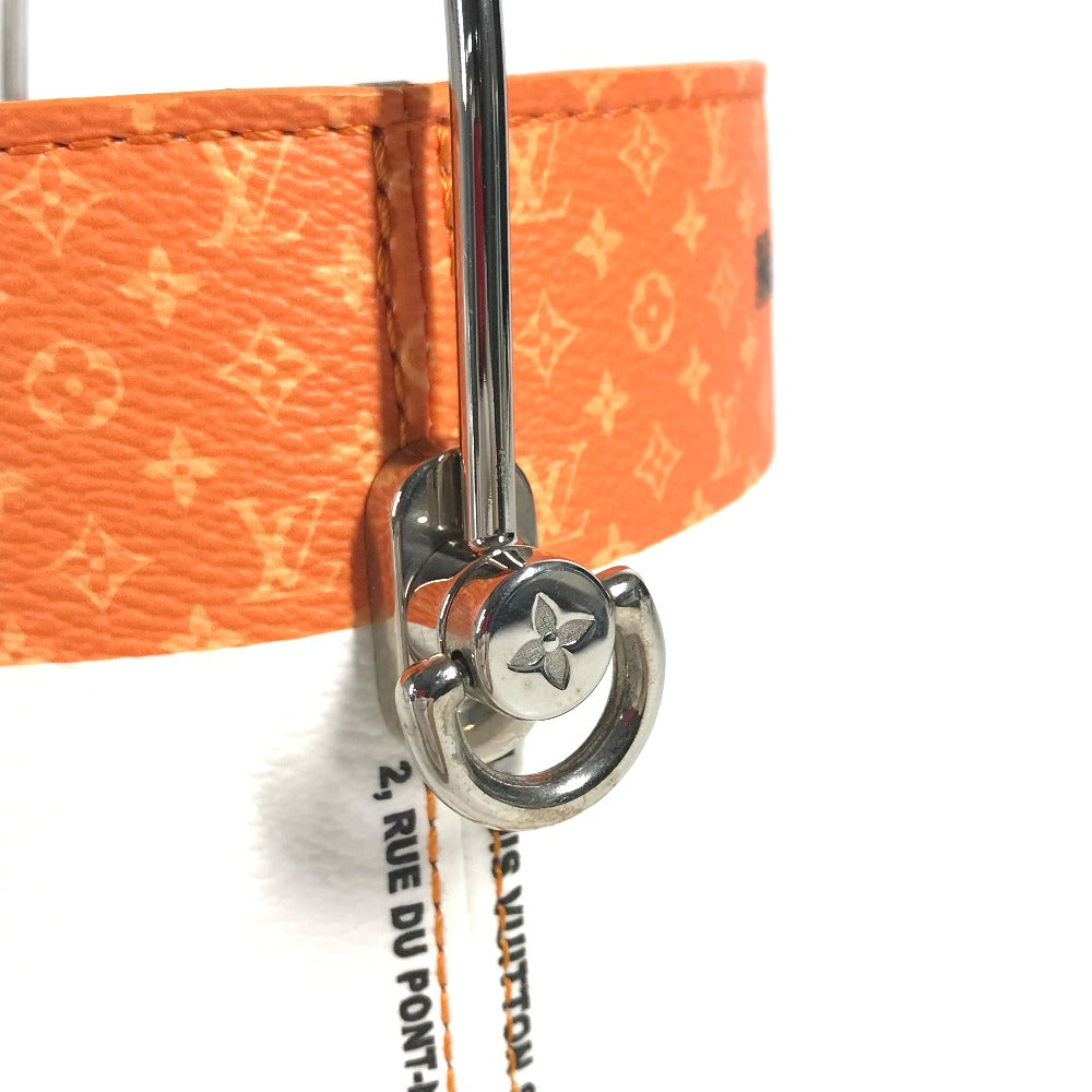 Close-up of a silver Louis Vuitton keychain on an orange monogram bag with '2, RUE DU PONT-NEUF' text.