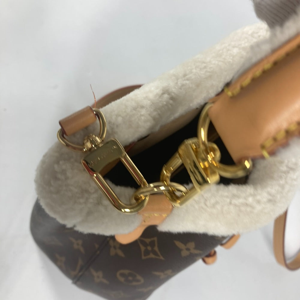 Close-up of a sandal with gold chain detail on a white background