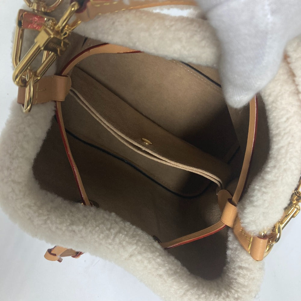 Brown leather handbag with gold accents on a white surface