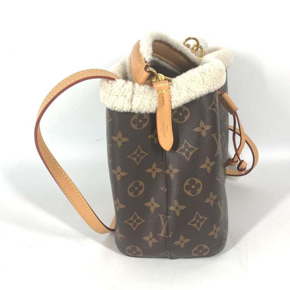 Designer handbag with monogram pattern and shearling interior on a white background