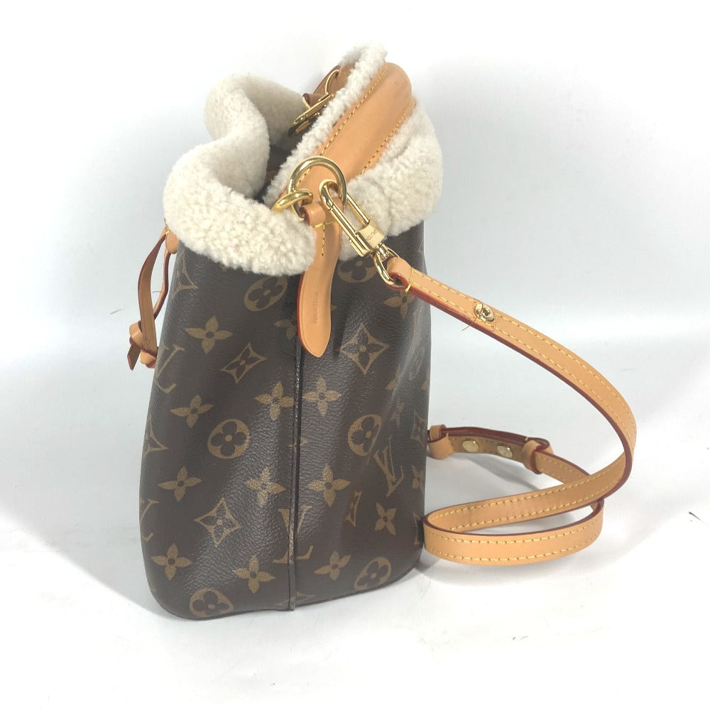Designer handbag with monogram pattern and shearling trim on a white background