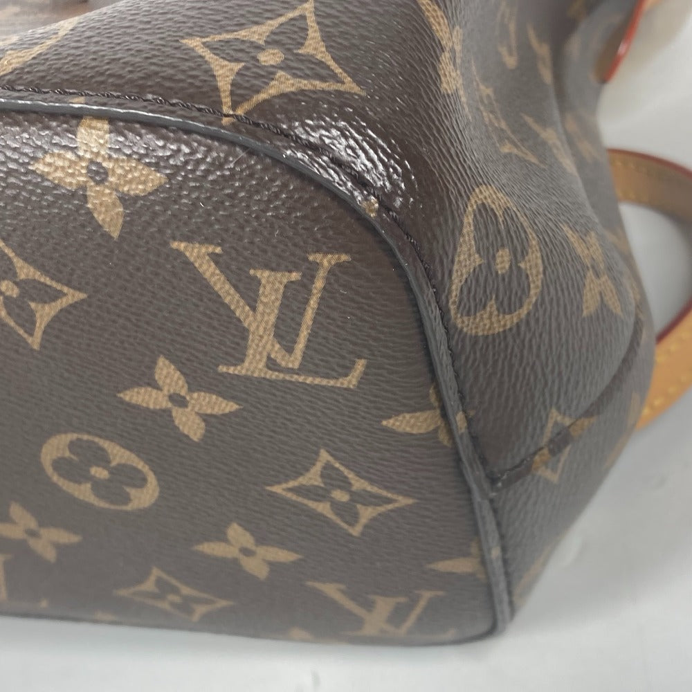 Close-up of a brown handbag with a prominent logo pattern on a white surface.