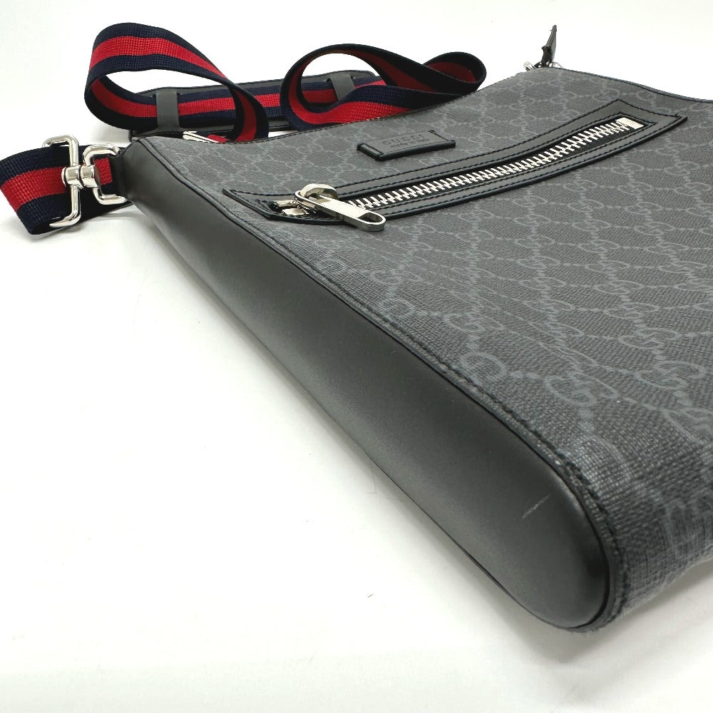Gray patterned bag with a red and blue strap on a white background