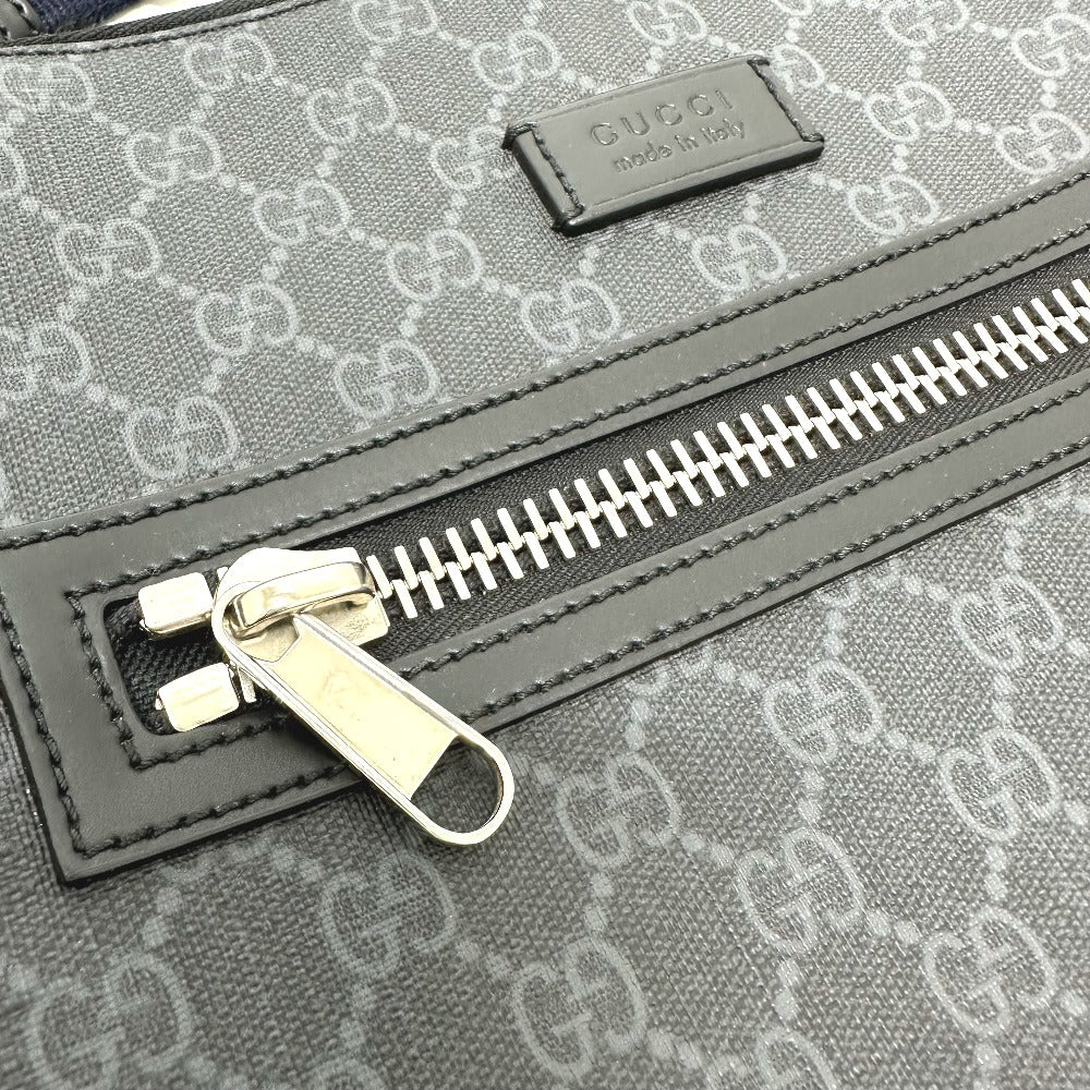 Close-up of a Gucci bag with a zipper and monogram pattern.