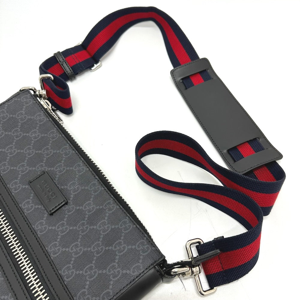 Gray patterned pouch with a red and blue striped strap on a white background
