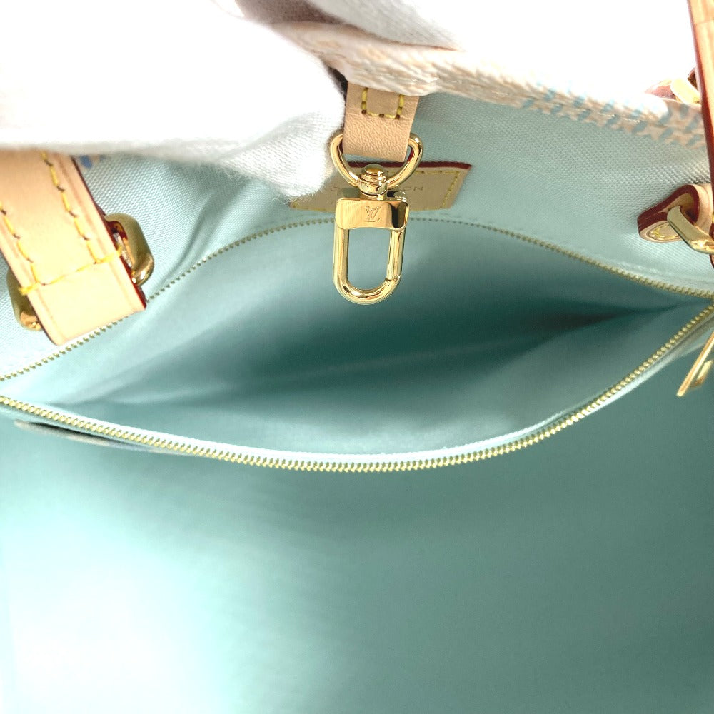 Close-up of a light blue handbag with gold hardware on a white background