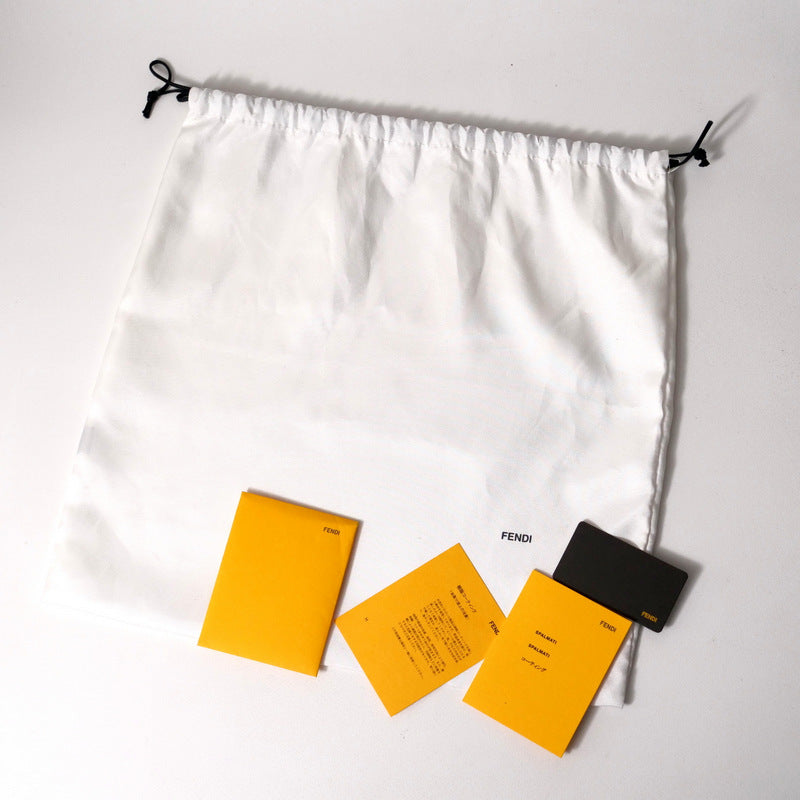 White drawstring bag with Fendi cards on a light gray background
