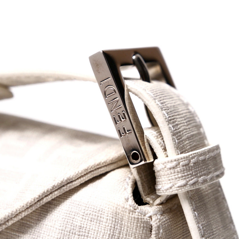 Close-up of a beige textured bag with a metal buckle featuring the brand name.