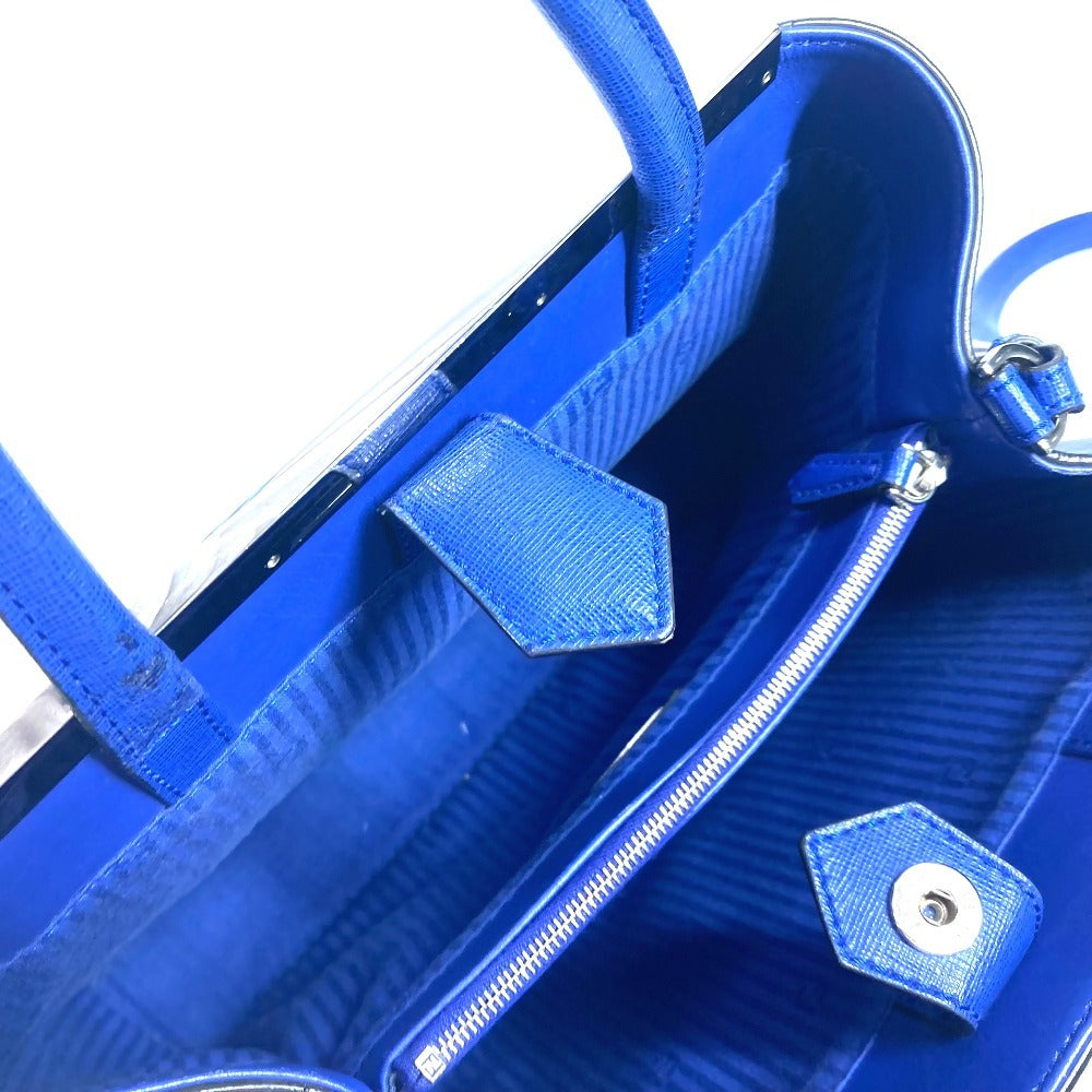 Close-up of a blue handbag with a zipper and handle details.