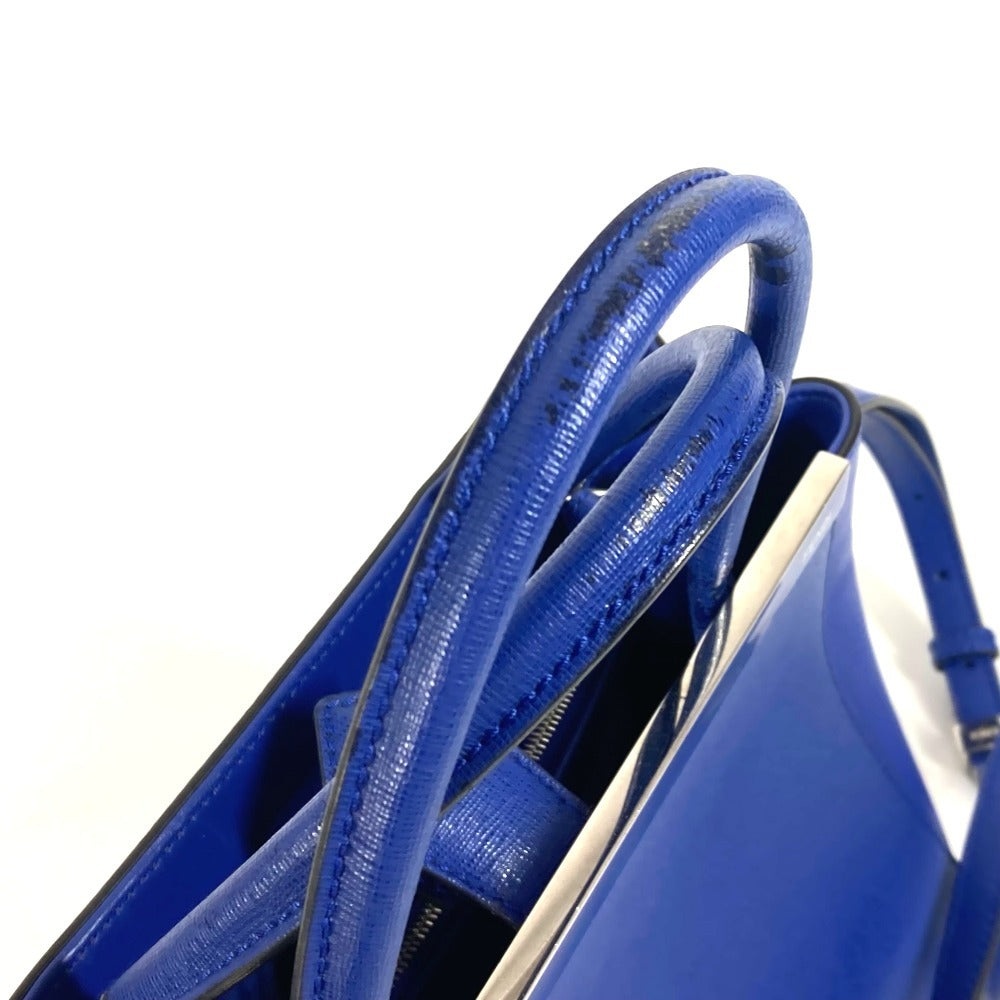 Close-up of a blue handbag with textured handle on a white background