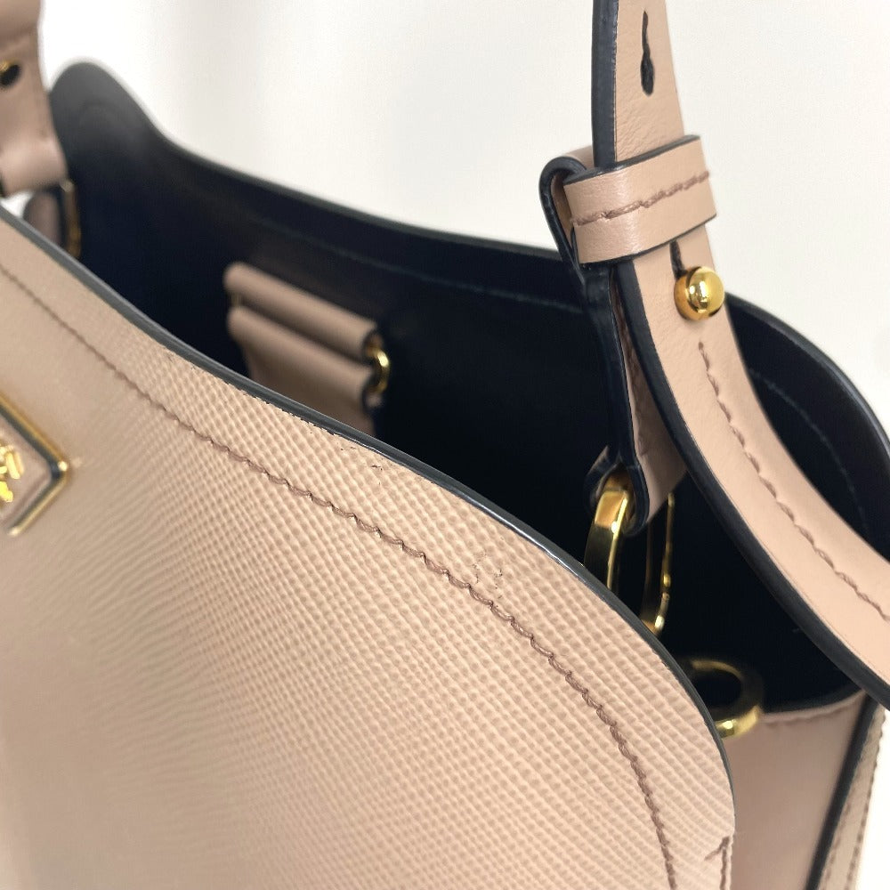 Close-up of a beige handbag with gold accents on a light gray background