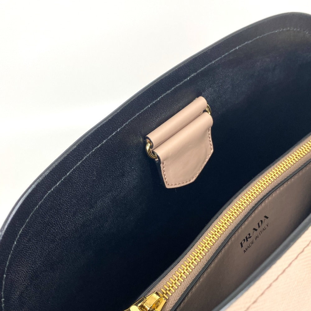 Close-up of a Prada handbag with gold zipper and beige flap on a white background