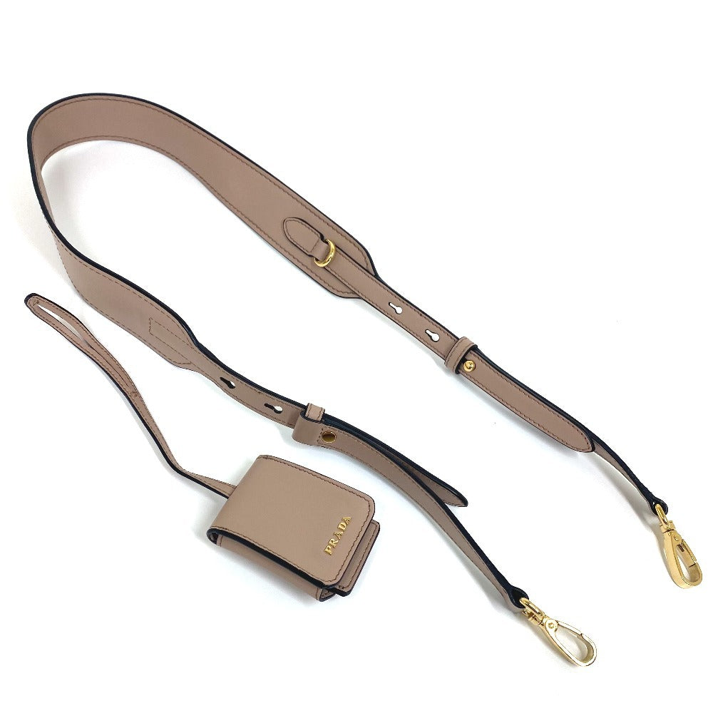 Beige leather strap with gold hardware on a white background