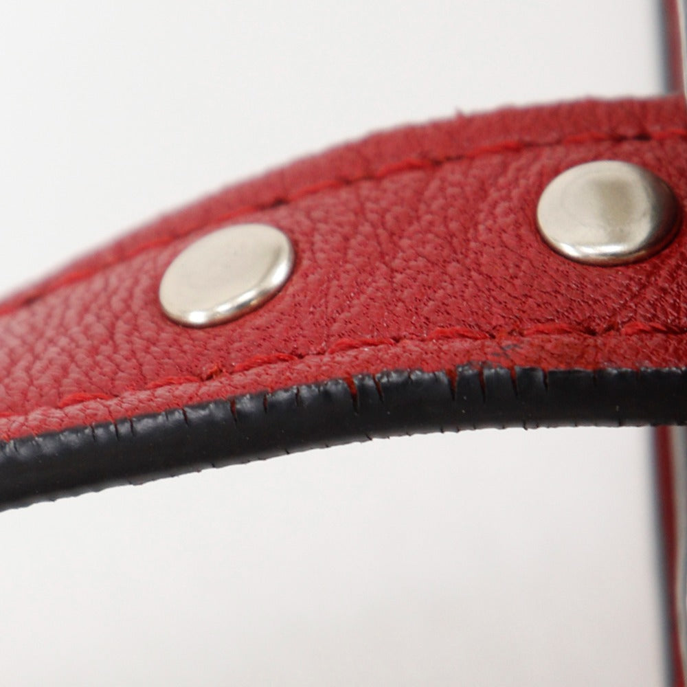Close-up of a red leather belt with silver studs on a white background