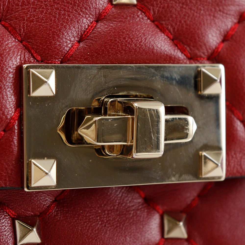 Close-up of a red quilted handbag with a gold clasp