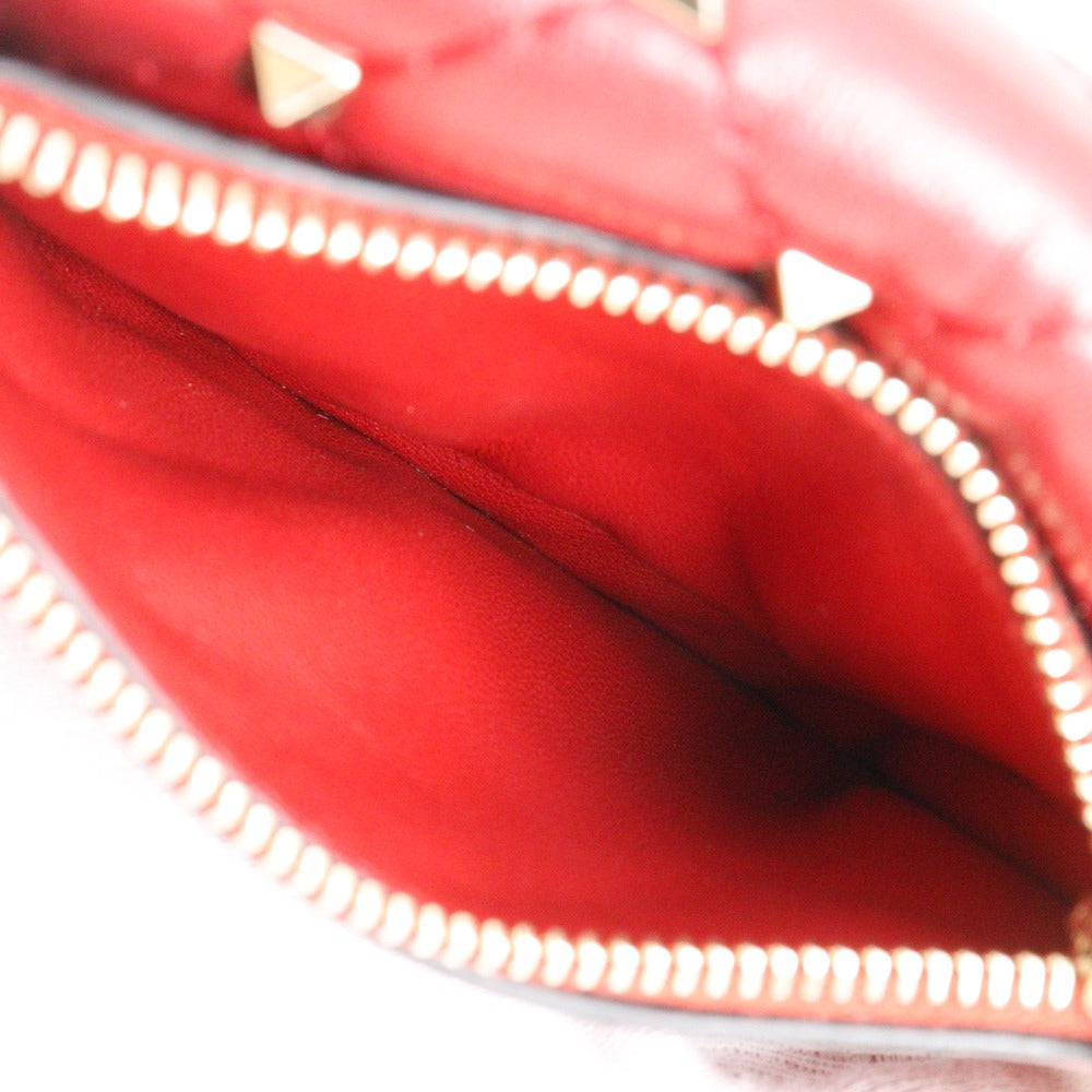 Close-up of a red pouch with gold zipper and studs.
