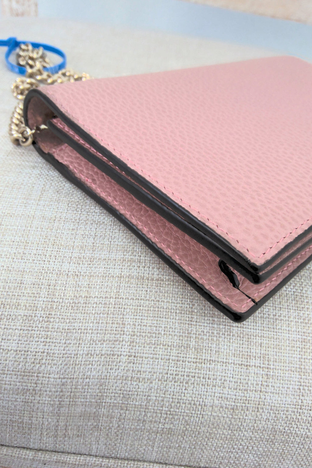 Pink wallet with black trim on a gray surface