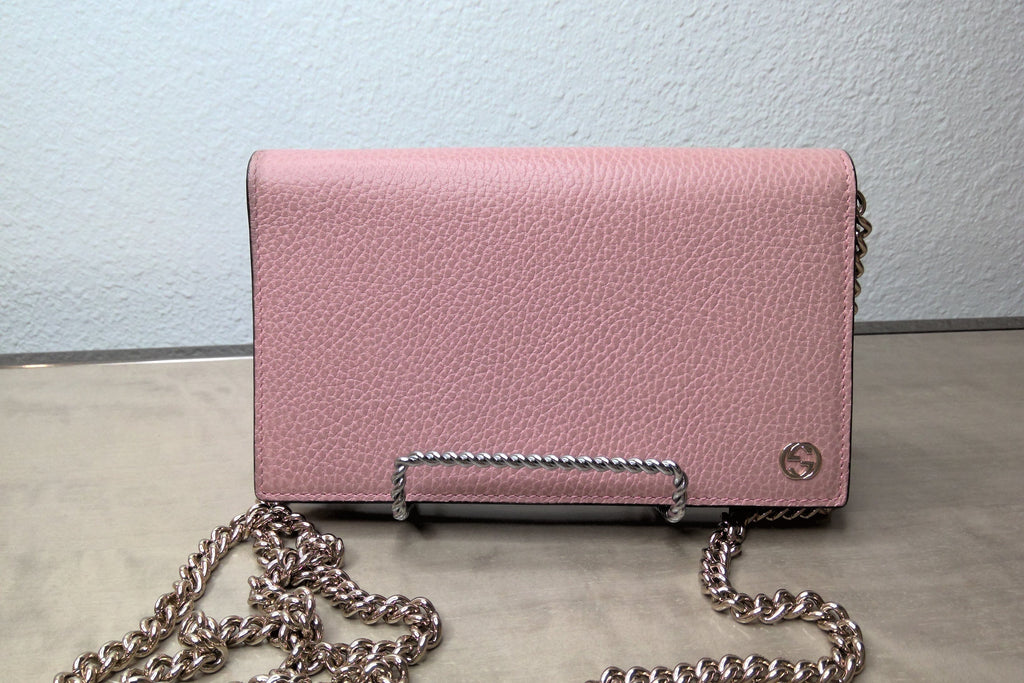Pink handbag with a chain strap on a light background