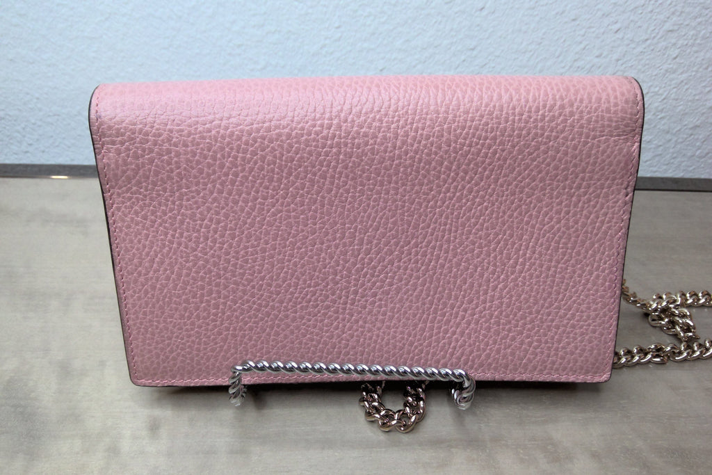 Pink handbag with a chain detail on a light blue background