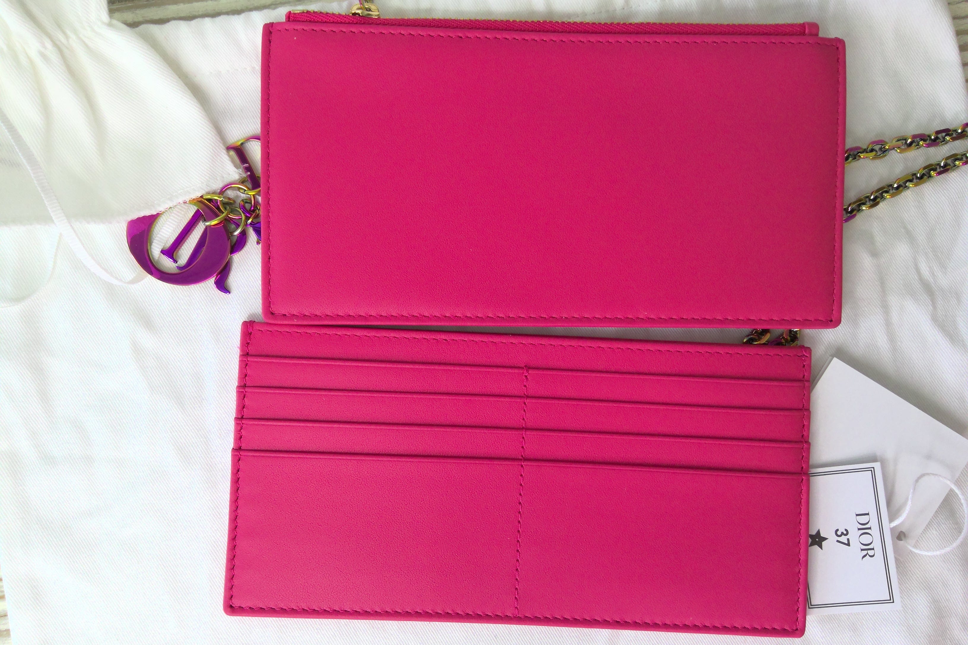Pink wallet with a chain strap on a white background