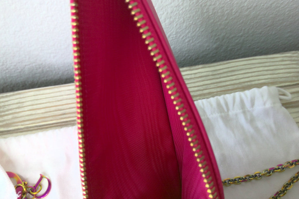 Close-up of a red fabric with gold zipper on a white surface