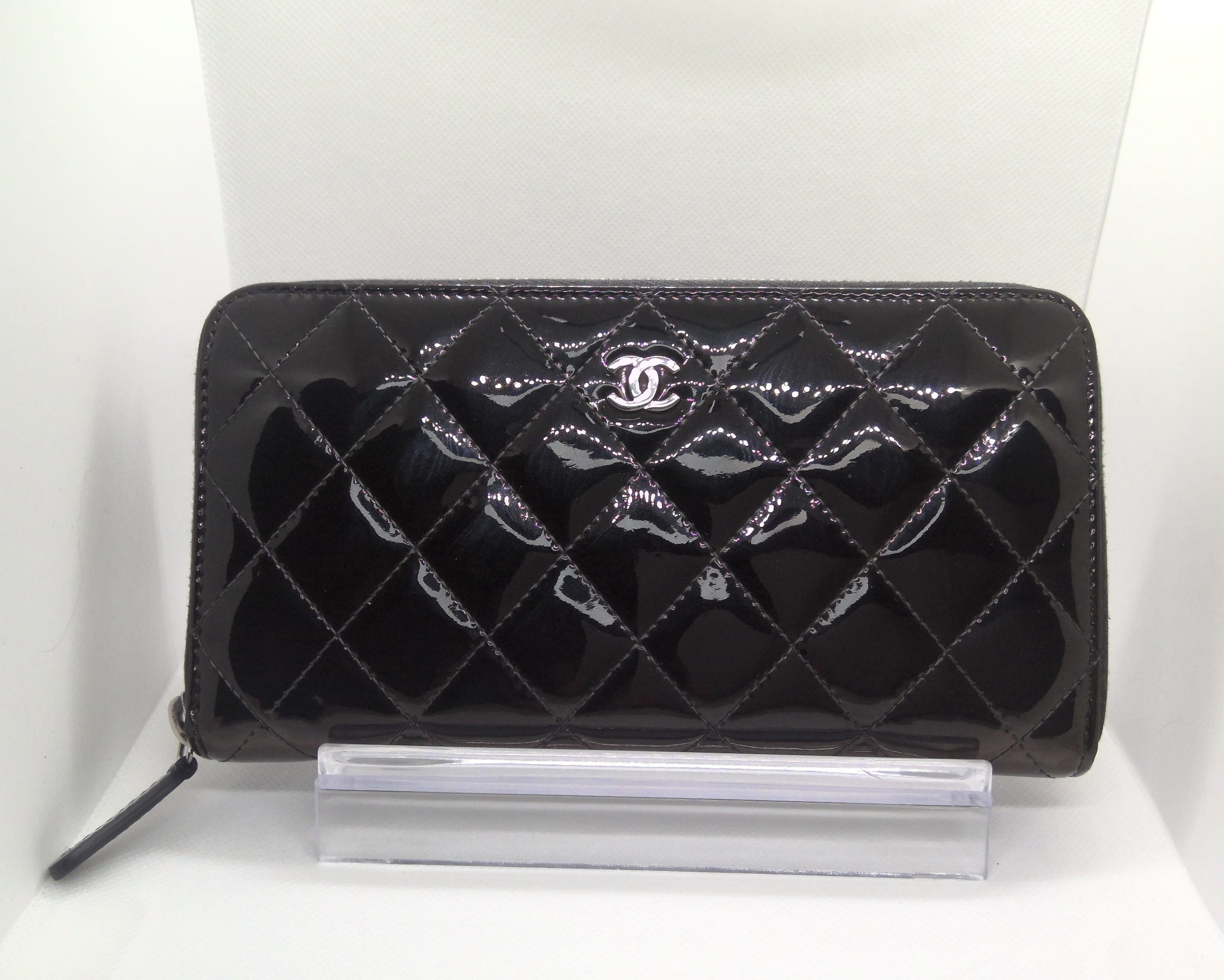 Black quilted wallet with Chanel logo on a white background