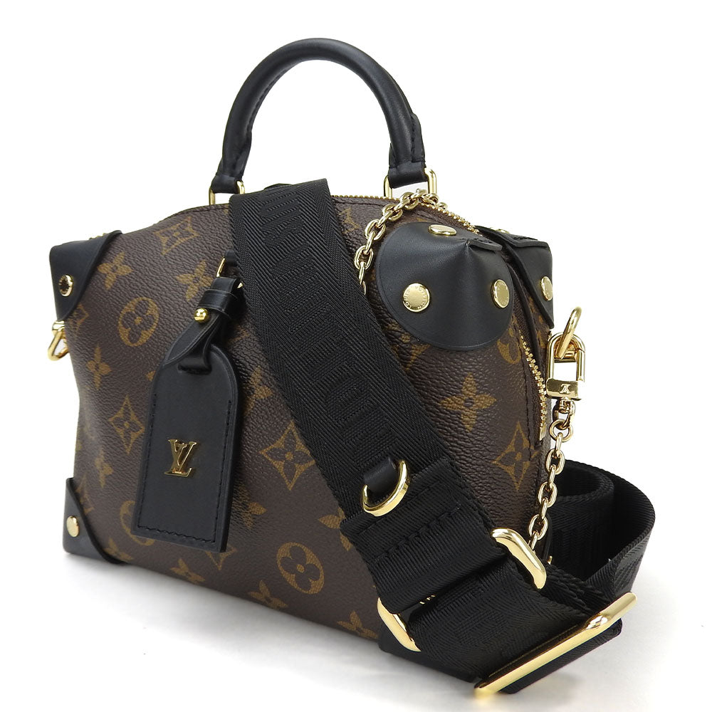 Designer handbag with monogram pattern and black straps on a white background