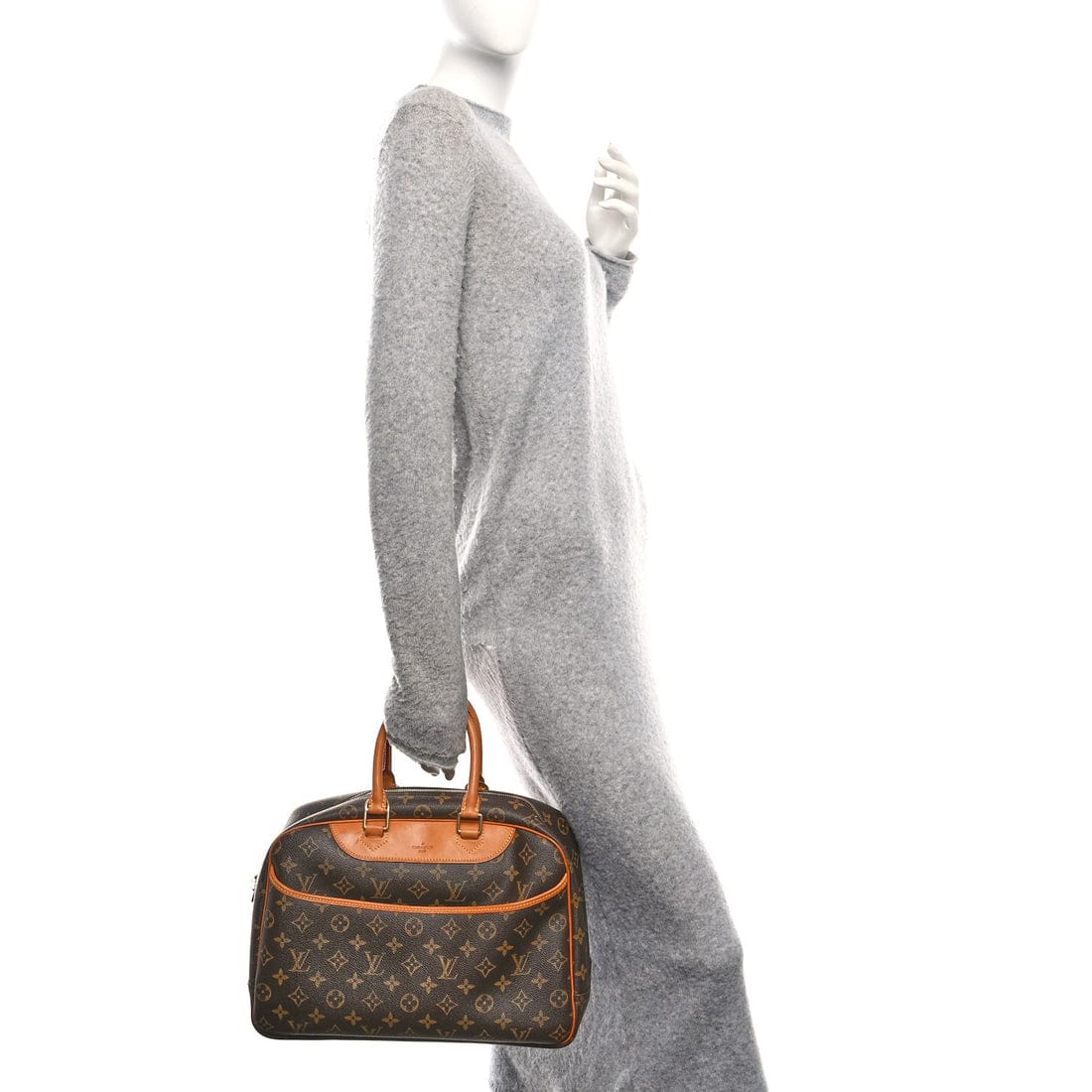 Mannequin wearing a gray sweater with a brown and orange handbag.