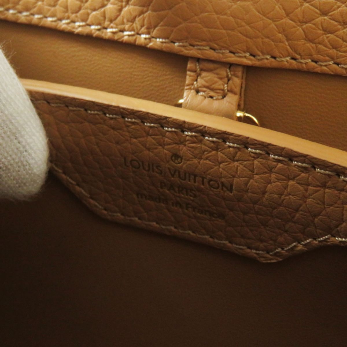 Close-up of a brown leather Louis Vuitton handbag with visible branding.