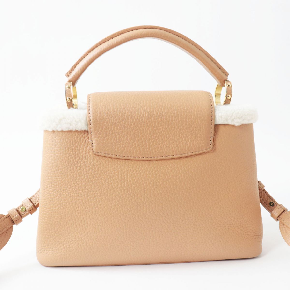 Beige handbag with a white interior lining on a white background