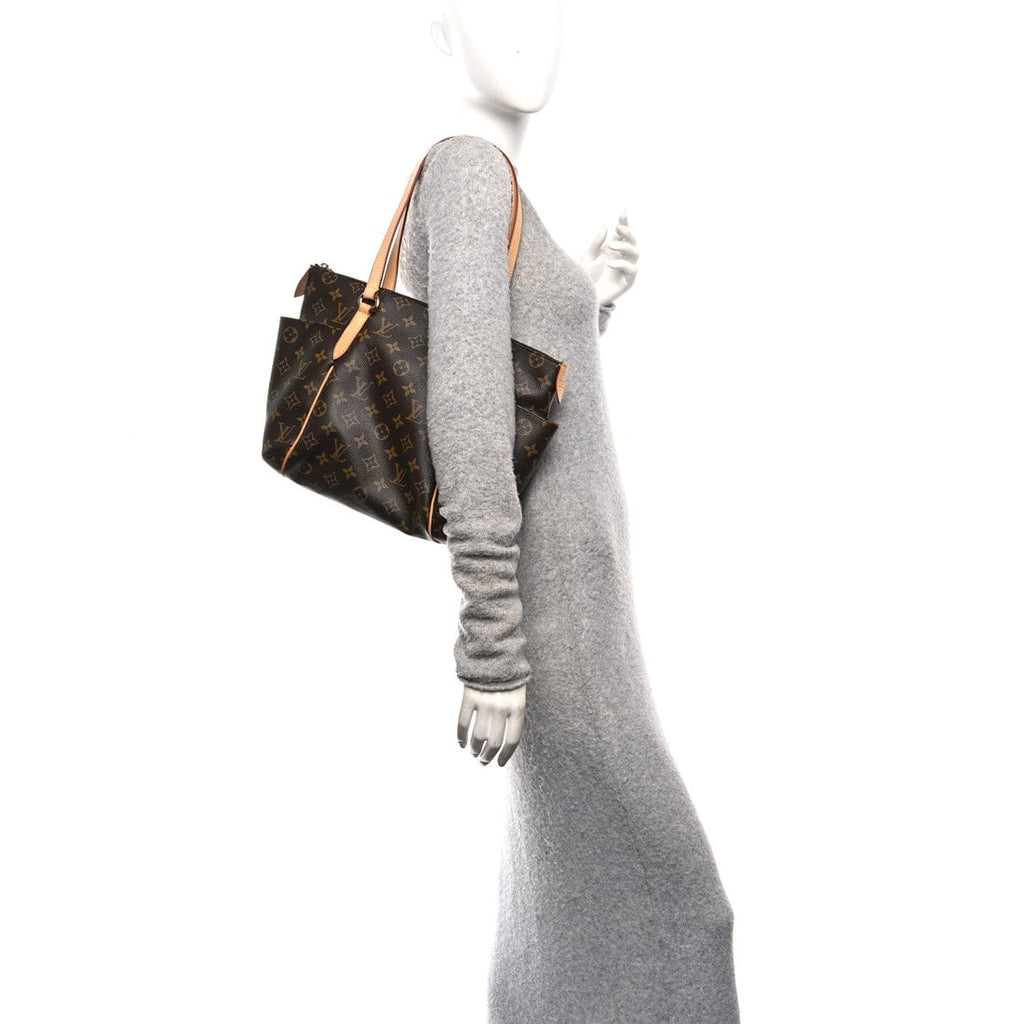 Mannequin wearing a gray dress with a brown handbag on a white background
