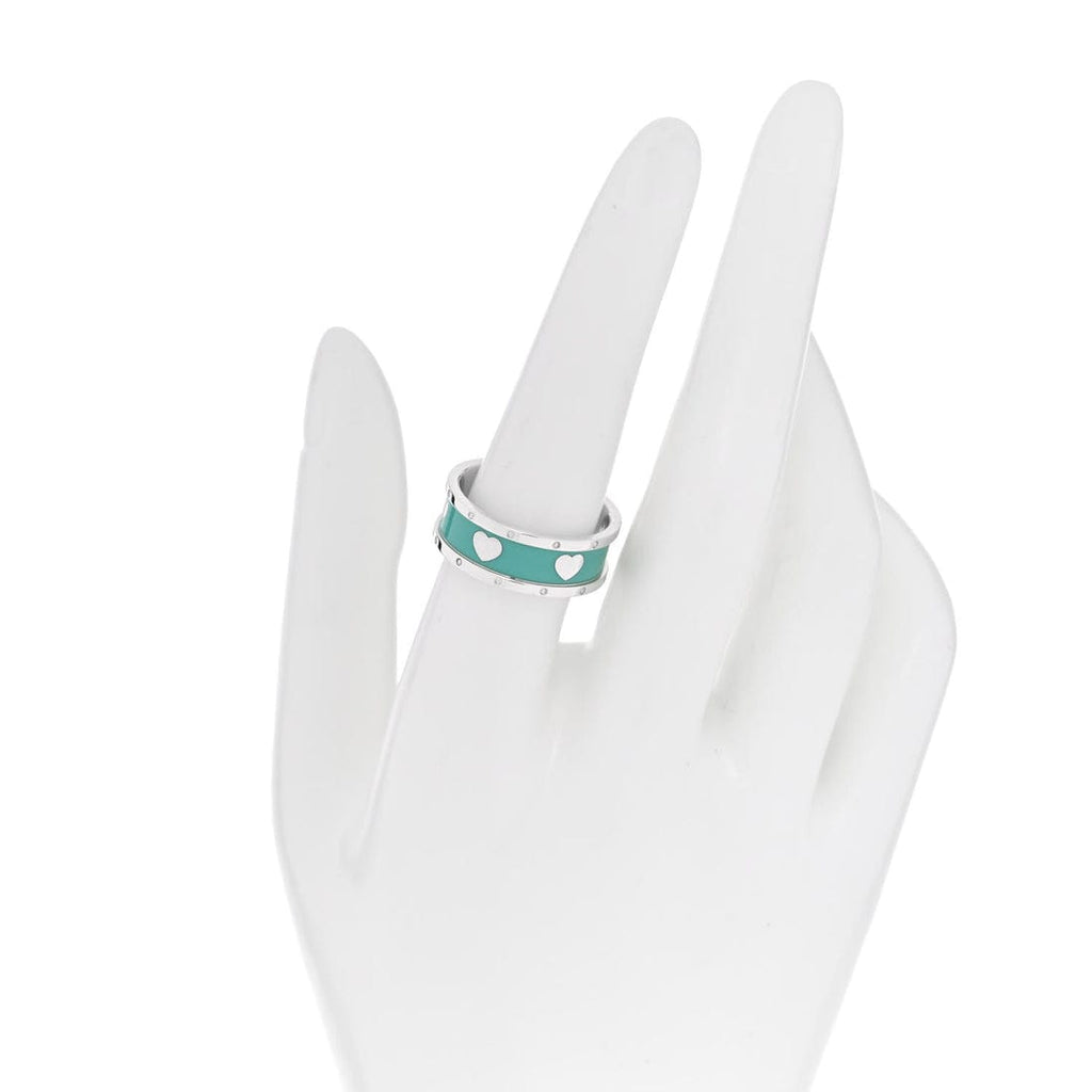 Turquoise ring with white polka dots on a white mannequin hand