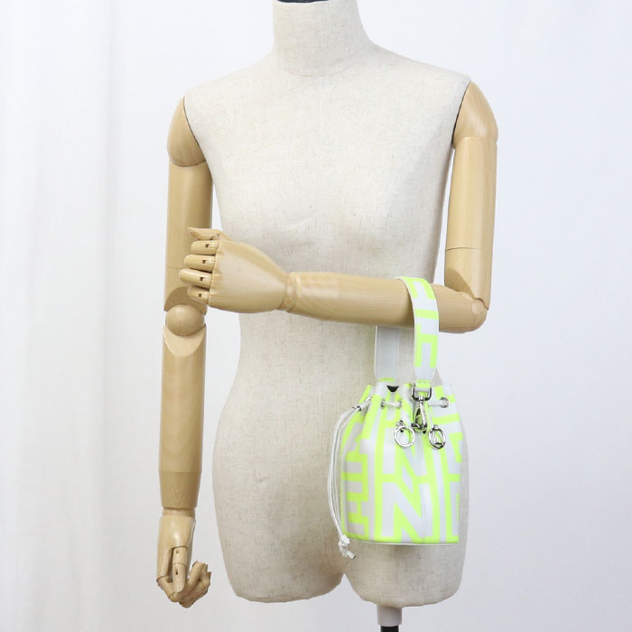 Mannequin wearing a neon green and white striped bag on a plain background