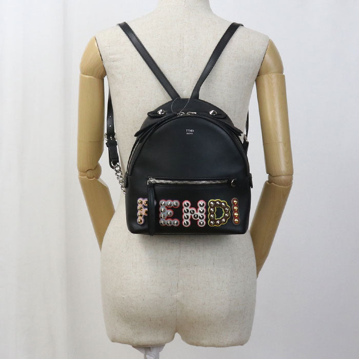 Black backpack with decorative elements on a mannequin against a white background