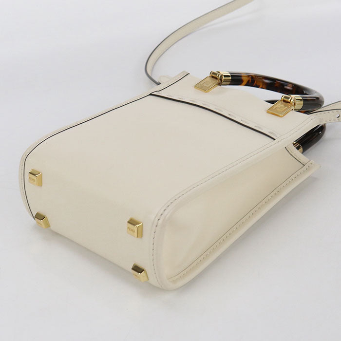 Beige handbag with gold accents on a white background
