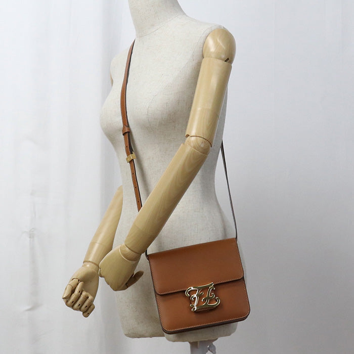 Brown handbag with gold clasp on a mannequin against a white background