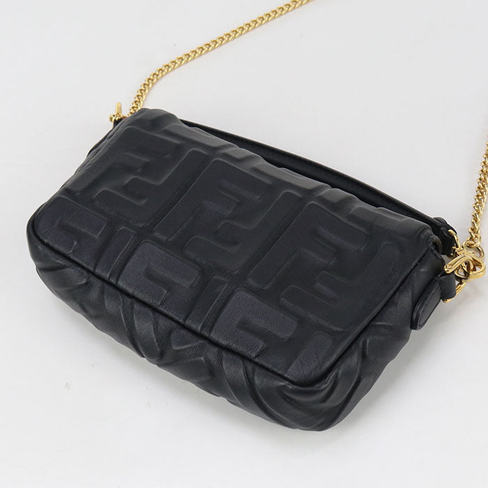 Black textured handbag with gold chain on a white background